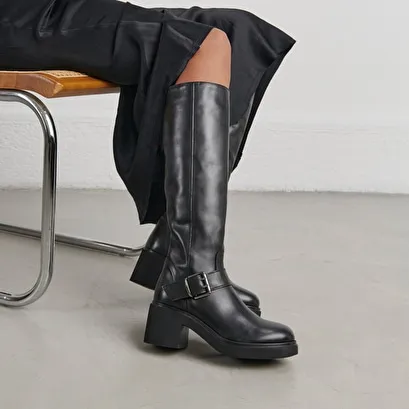 Boots with thick soles and side buckles in black leather